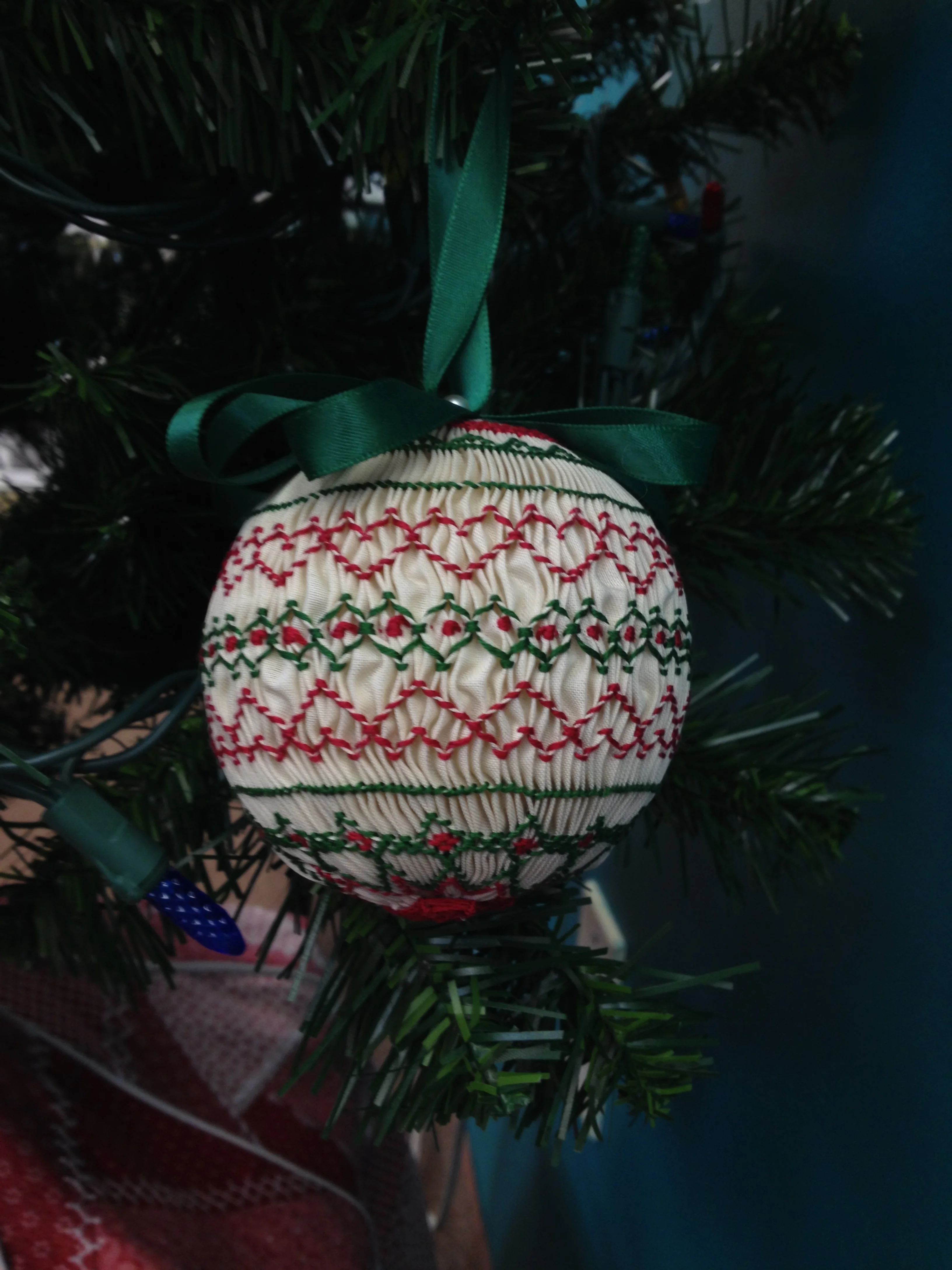 smocked ball in red hearts and green motifs on all-white fabric
