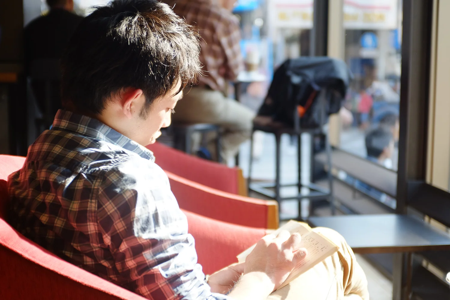 A man reading a book at Starbucks on Kokusai street in Naha, Okinawa, Japan. Fuji x100s w/ TCLx100 Teleconverter at ISO 400, f2, 1/80 sec.