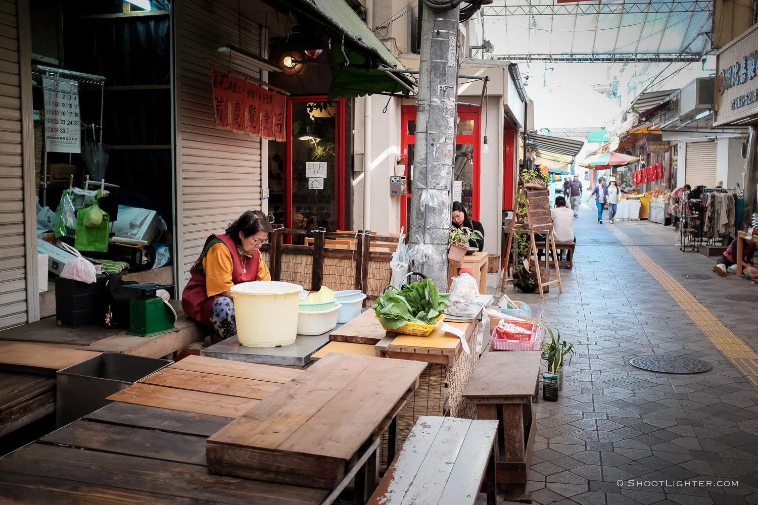 An elderly lady sells vegetables in Naha, Okinawa Japan. Fujfilm x100T, ISO 320, f/2.0, 1/60 sec, Fujifilm chrome film emulation, edited in Adobe Lightroom 6.
