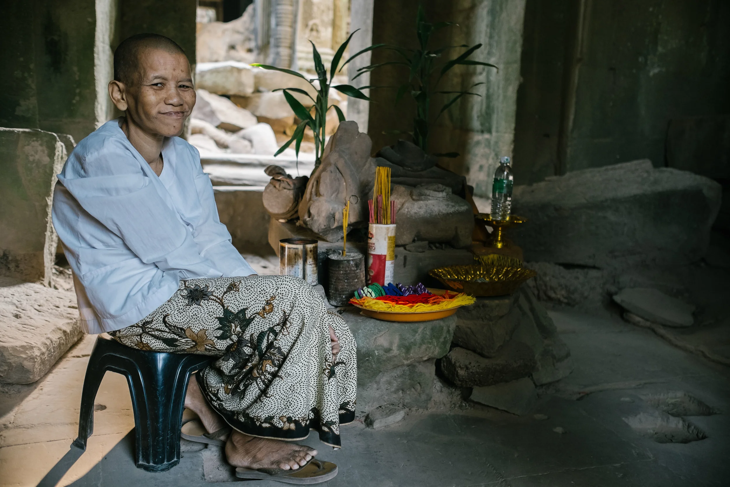 An old lady setups her good luck bands inside Ta Prohm.&nbsp;Fuji X-Pro 1, 14mm f/2.8