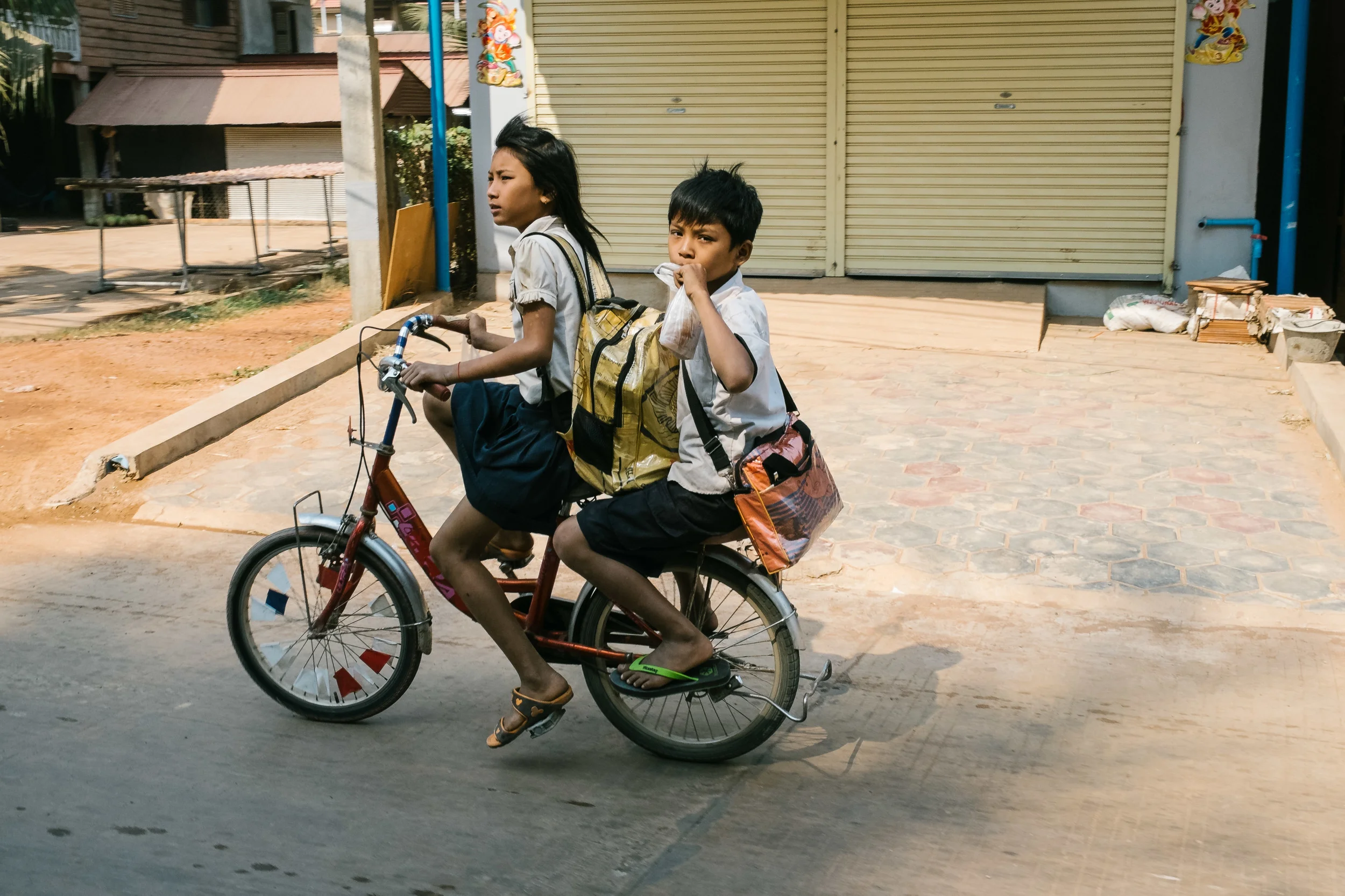 Kids double on a bike to get to school. Fuji X-Pro 1, 23mm f/1.4