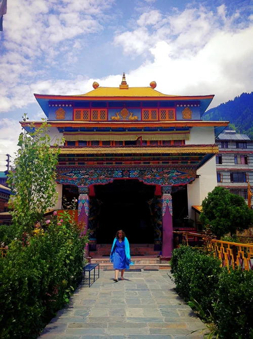 Mikayla walking in front of the Nyinmapa temple - inside is a two story golden statue of Buddha