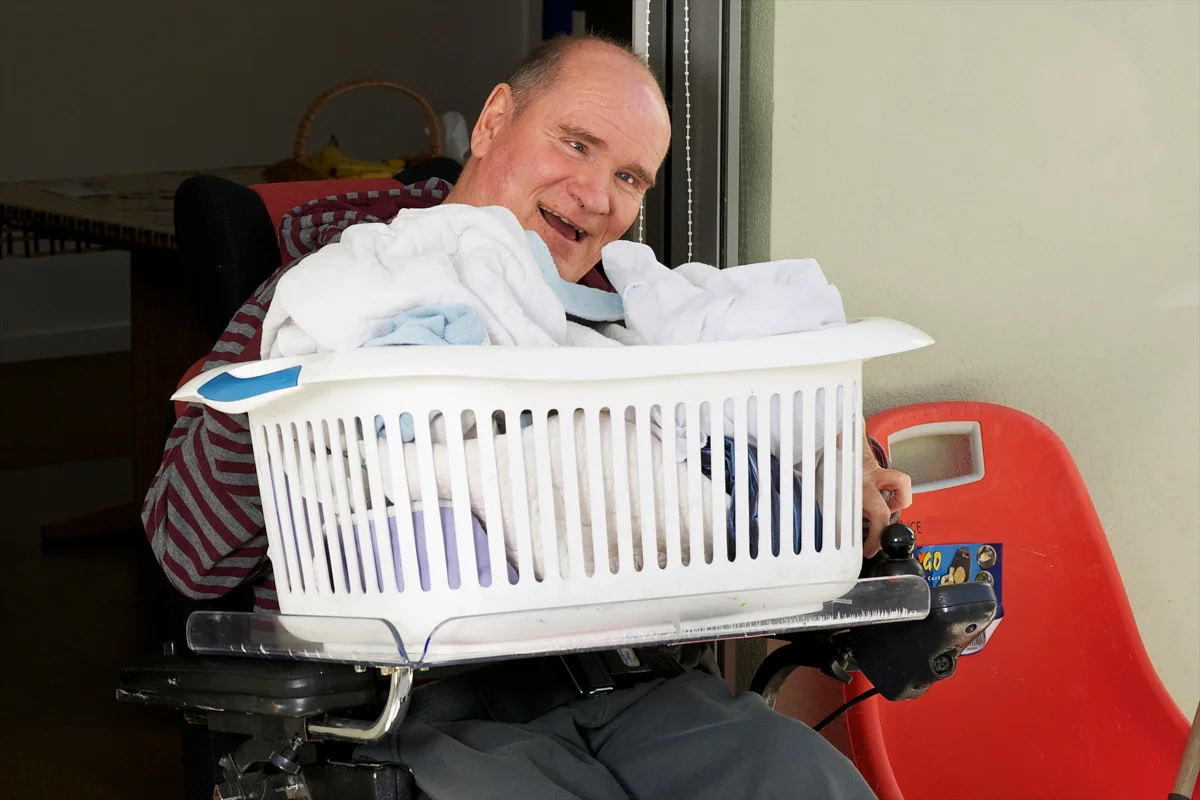 20100313-man with a disability holding a clothes basket.jpg