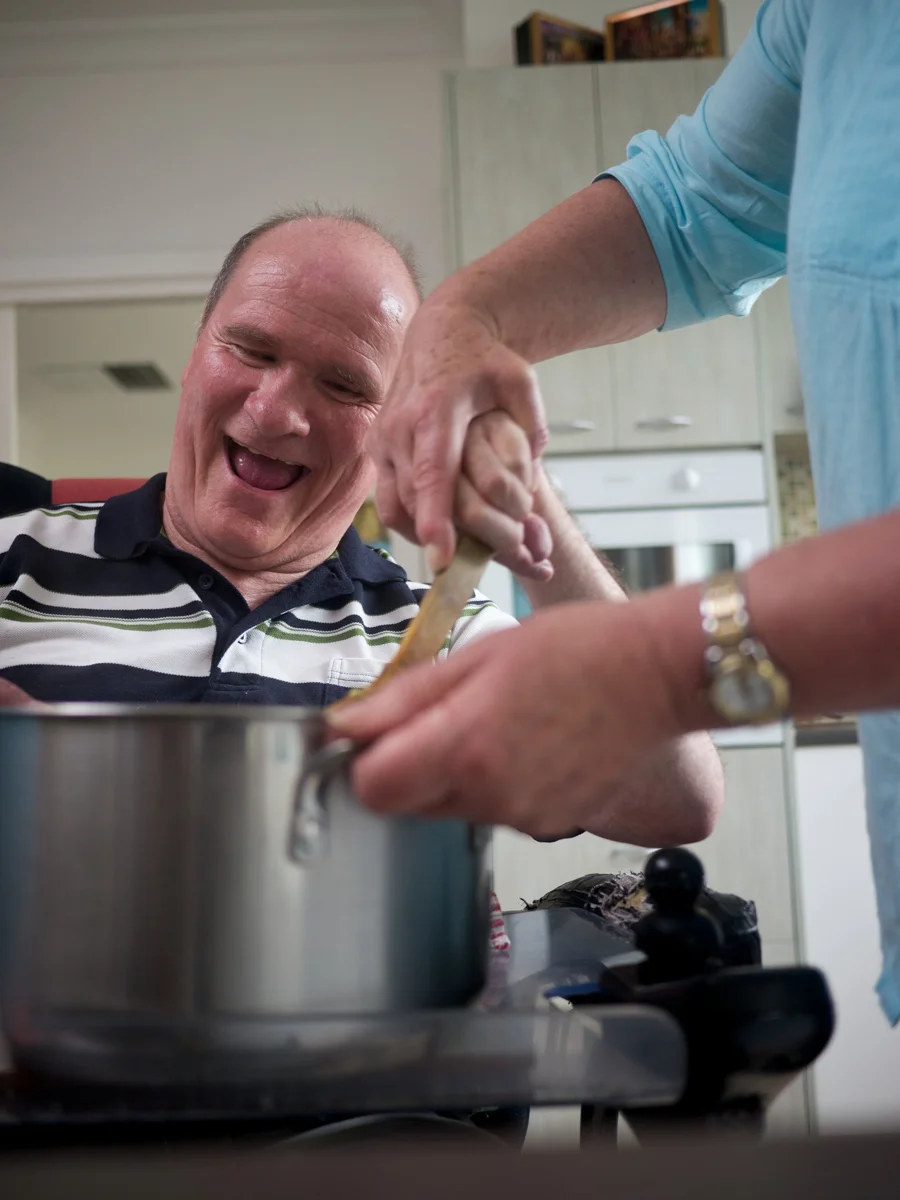 20110112-fifty-six-year-old man being helped to stir a pot(1).jpg