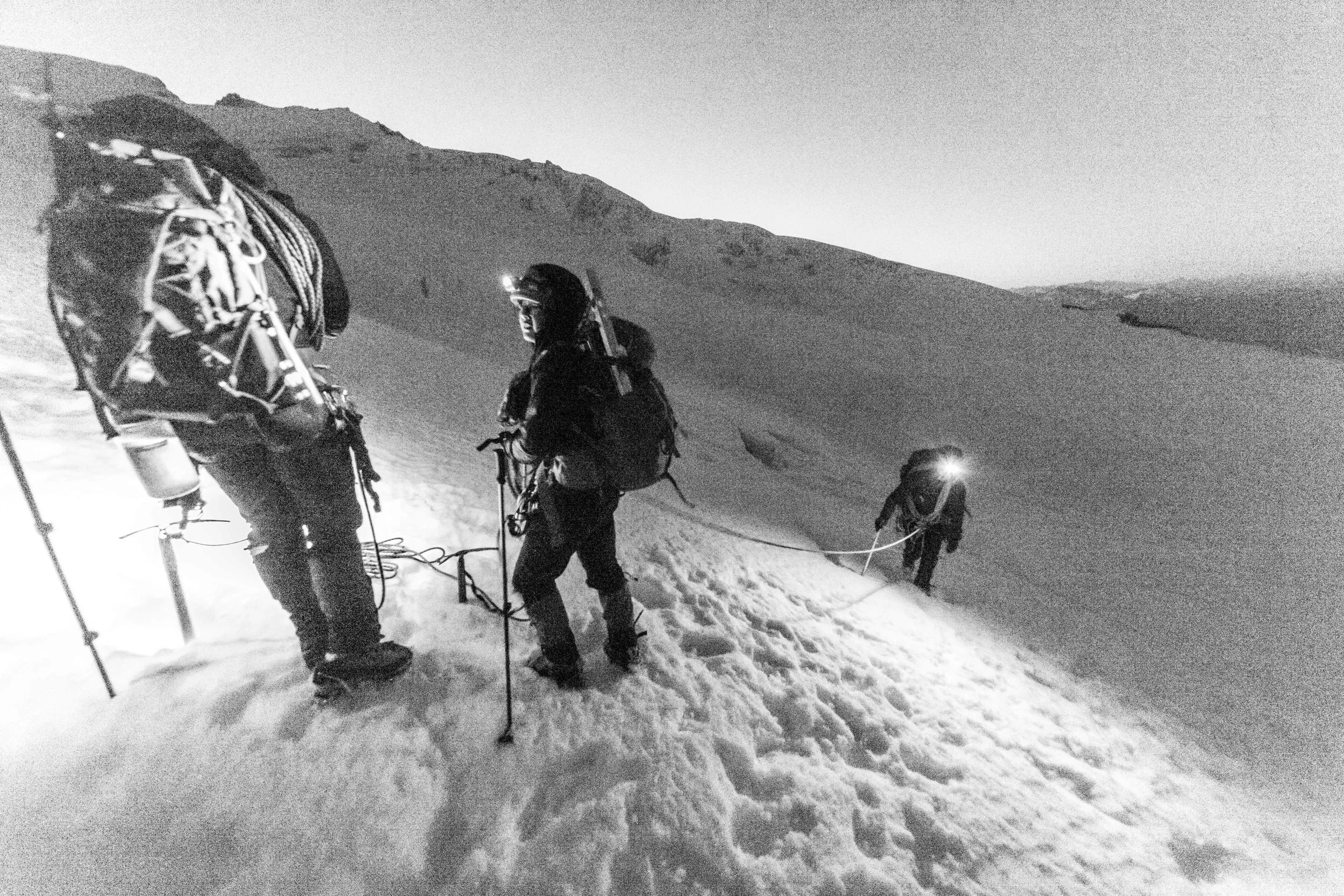 Climbing up the Easton Glacier by headlamp. Note the slushy snow and deep prints; alpine starts are meant to avoid those issues. Encountering them this early is a bad sign.