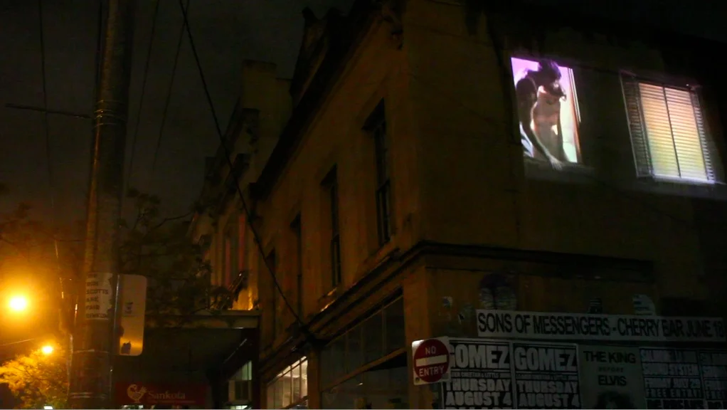 Vertigo in time , is a site projection of eerie shadows and back lit figures looking out of windows. The film uses repeated and slowed excerpts form Rear Window (1954). The building was a boarding house and was derelict until the early 1990's when it was occupied by artists and students. The work was projected onto concreted windows on the corner of little Smith Street lane and Gertrude Street Fitzroy, Melbourne.
