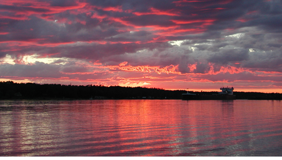  This is the sunset view from our cabin in Michigan. My
husband and I spend part of our summer vacations there. The cabin is on an
island in the Ste. Marie's river where large ore boats pass by on their way to
Lake Superior. 