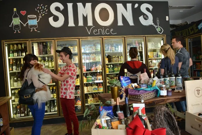 Happy shoppers mingle at the newly-opened Simon's Provisions on Rose Ave., a craft beer, wine and snack store that took over the former Rose Market liquor store. ( Photo by Angelina Attwell )