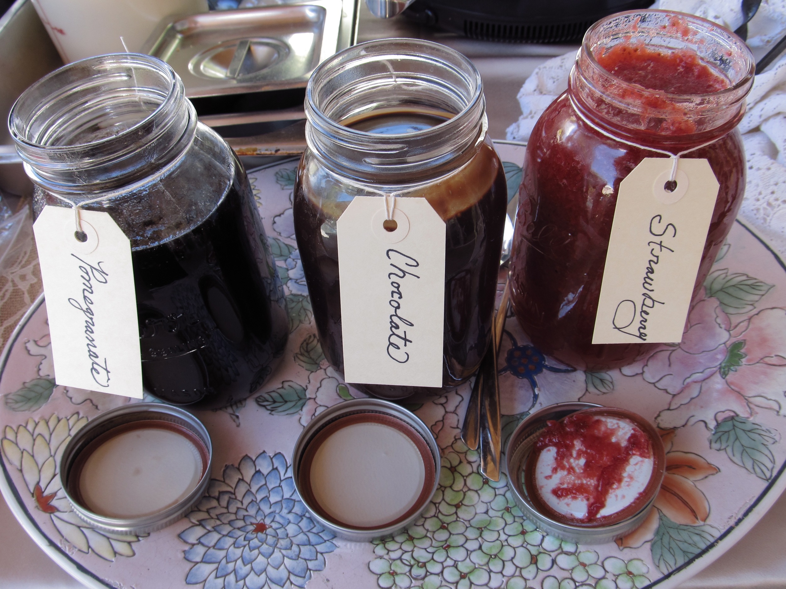 Pomegranate, chocolate and strawberry sauces ready to drizzle on the beignets.