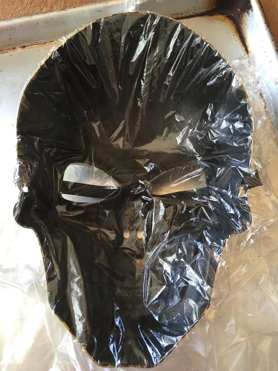 Line a clean Halloween mask with plastic wrap. Pros wrap down into all crevices and make sure wrap extends beyond mask.