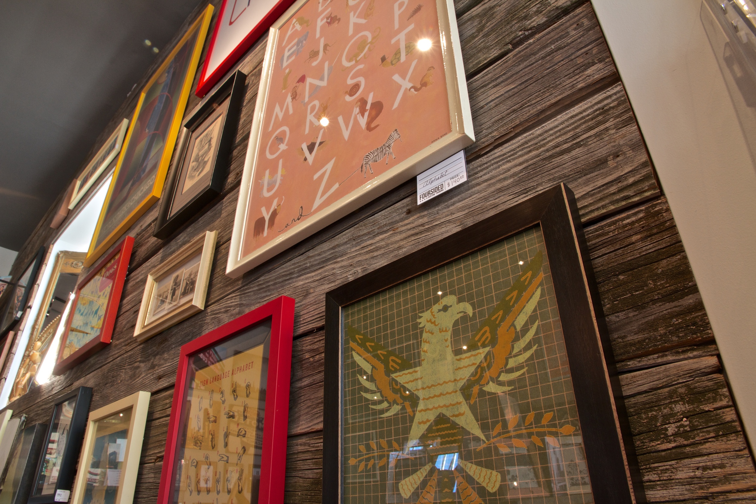 A reclaimed barn wood wall was created to break up the customer journey and provide a rich backdrop to hung artwork.