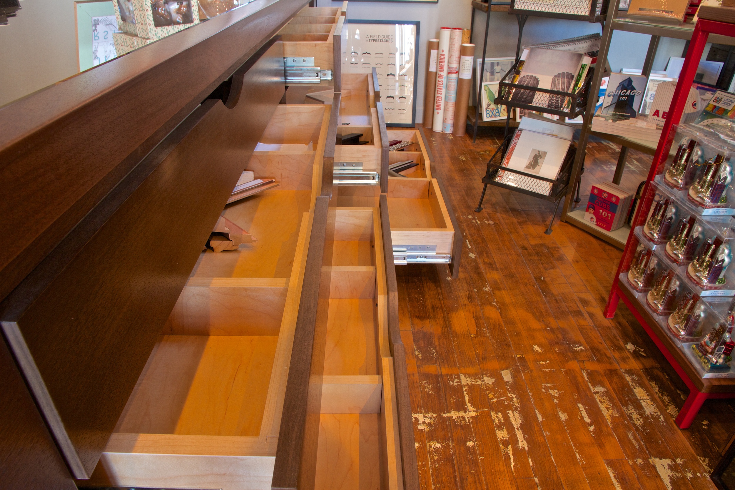 Kaper Design designed custom cabinetry with large flat file drawers to hold extra frame samples, prints, and more. 