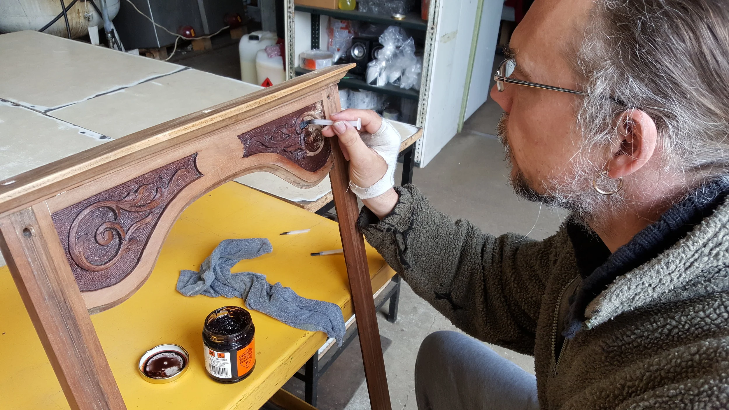 Painting brown Beeswax polish onto the recessed areas and white paint.