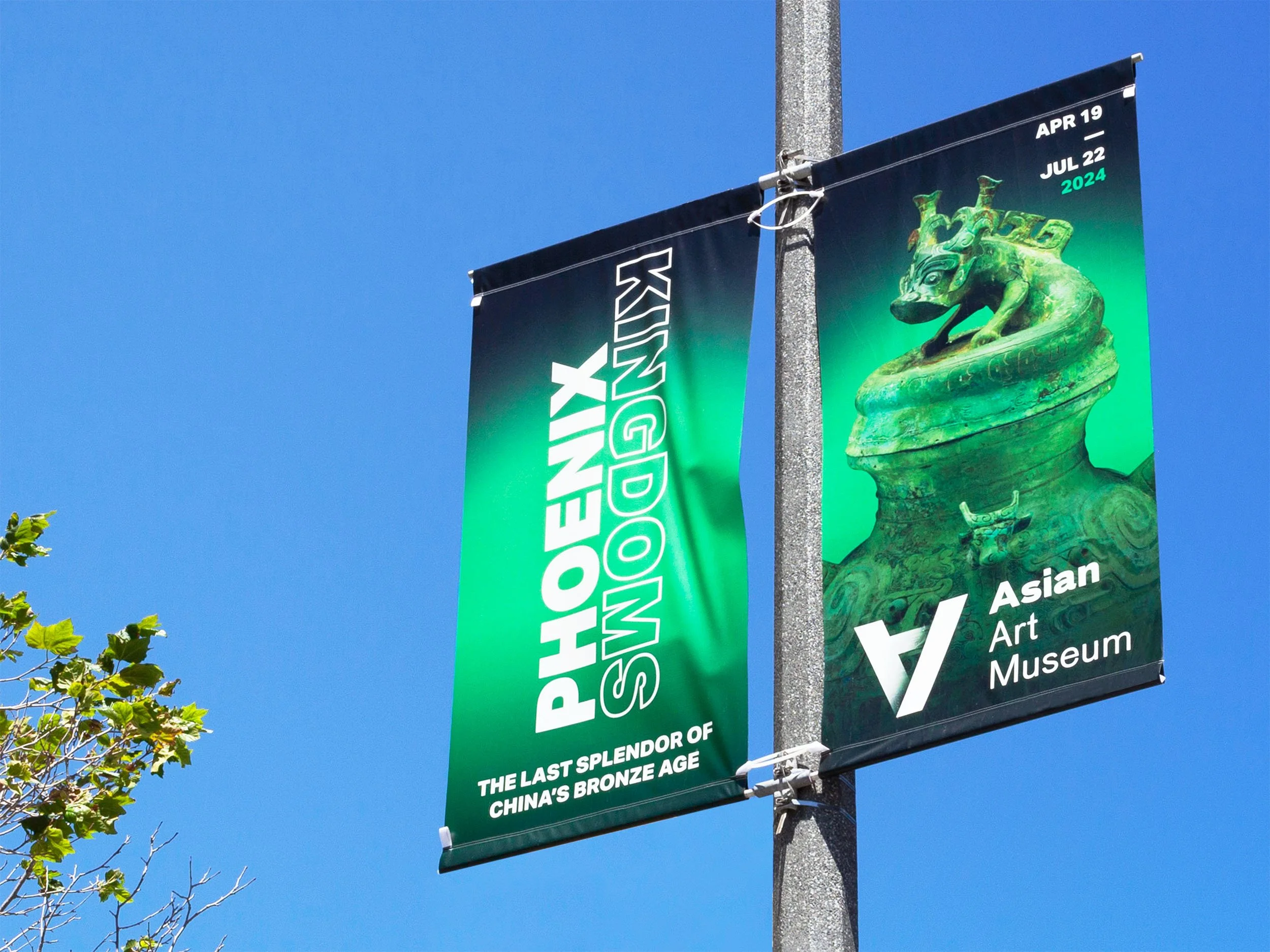 Vertical banners for the Phenix Asian Art Museum promoting the exhibition 'Kingdom' about China's bronze age, with dates April 19 to July 22, 2024. One banner has white text on a green gradient background, and the other features a large image of a green Chinese dragon statue.