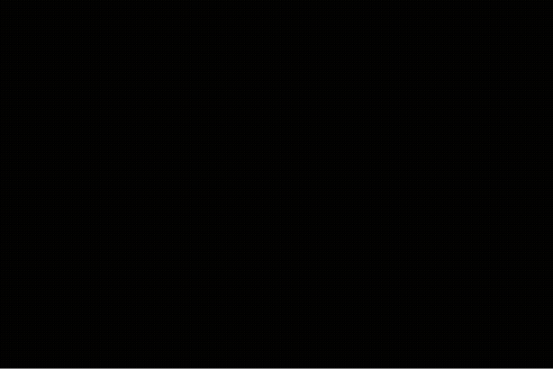 A video of a woman behind a sheer curtain turning directly toward the camera and a white logo appearing over the center of the image.