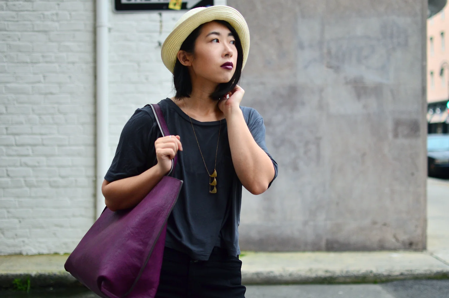 Ally looking towards the road. Wearing Aritzia fedora hat, Crafts & Love necklace, Urban Outfitters leather tote, and Gap slub tee.