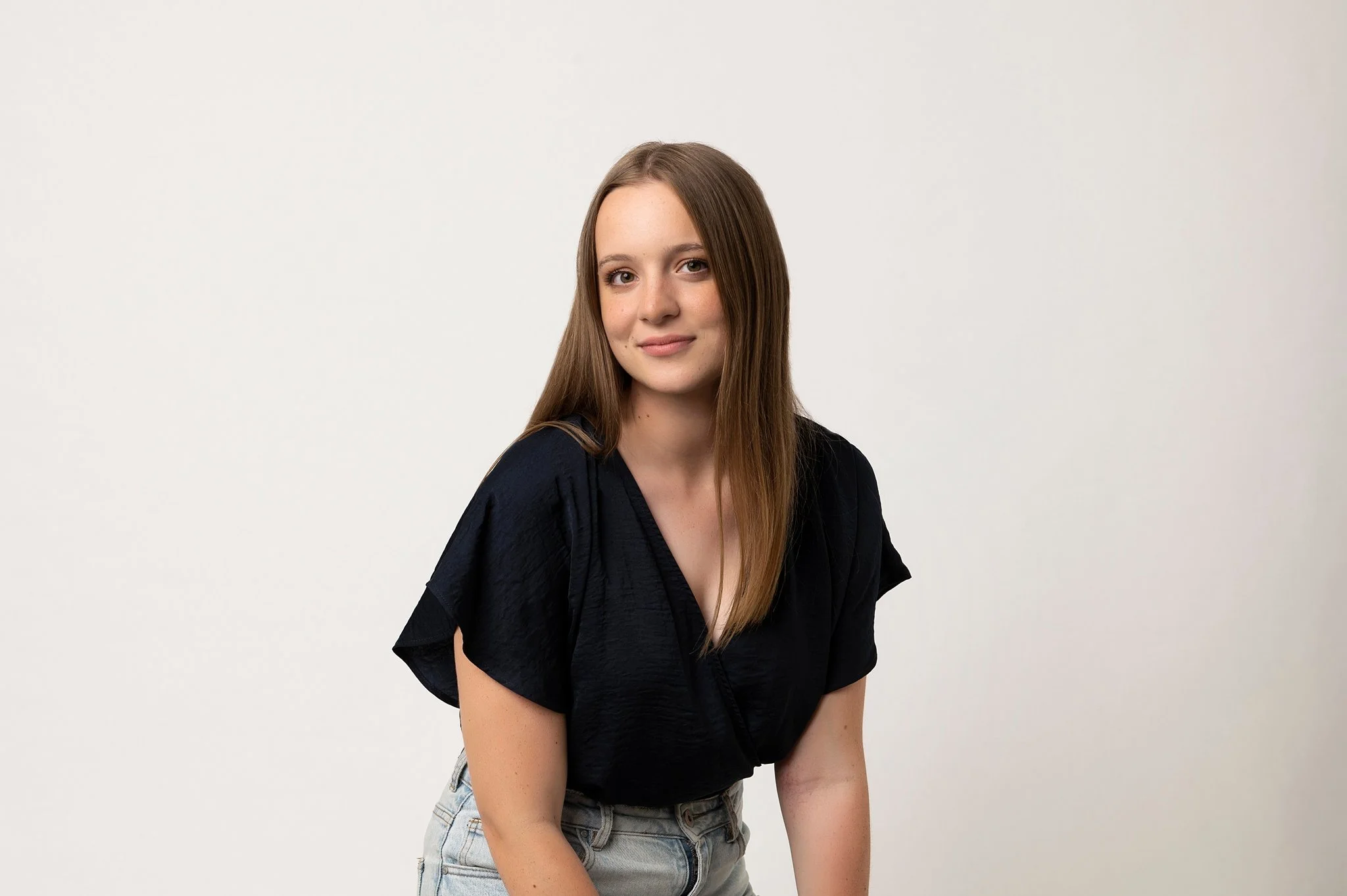 Professional woman with a calm, serious expression in a corporate headshot on a white studio background