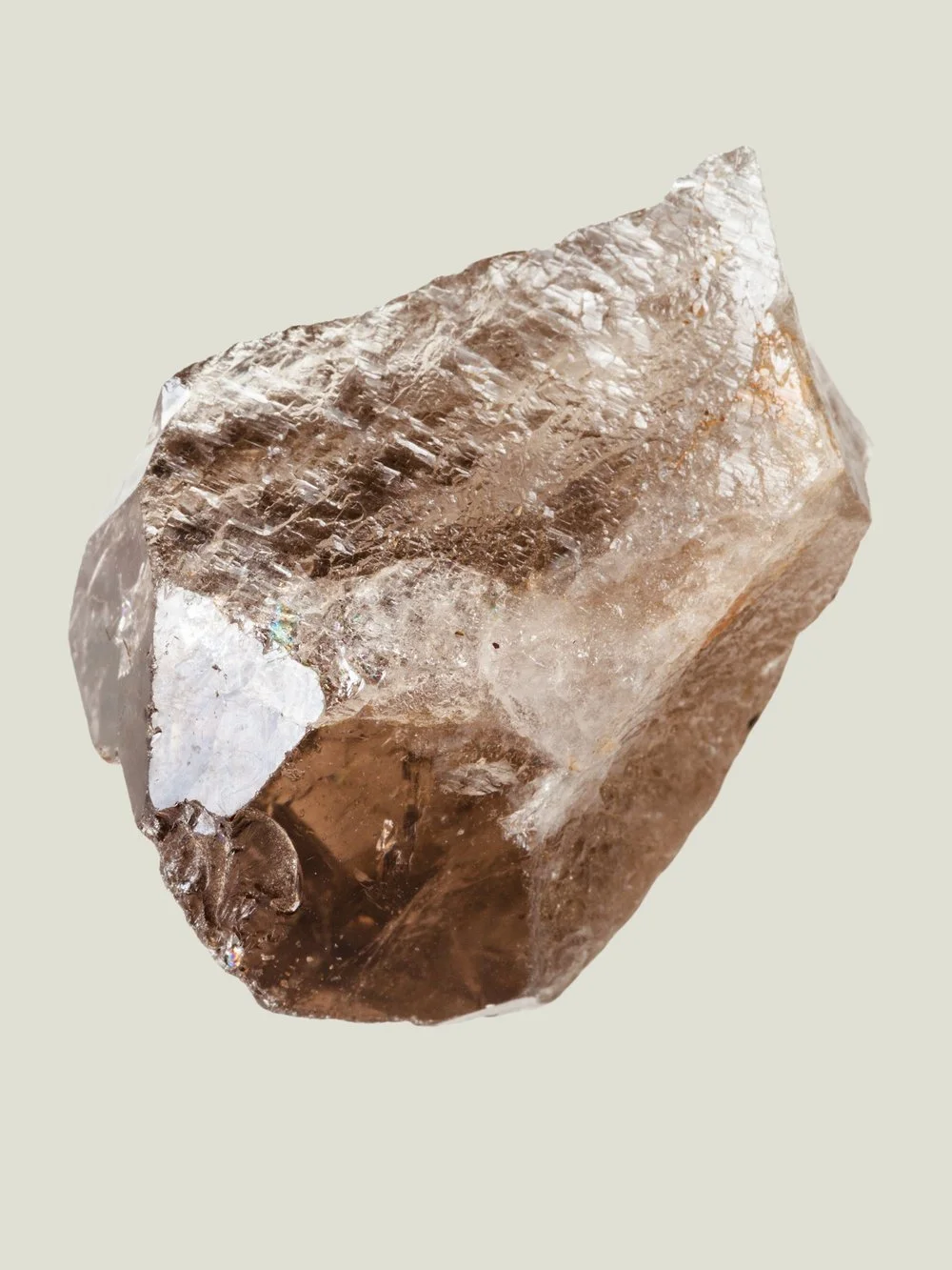 A close-up of a raw, uncut quartz crystal with a rough, irregular surface.