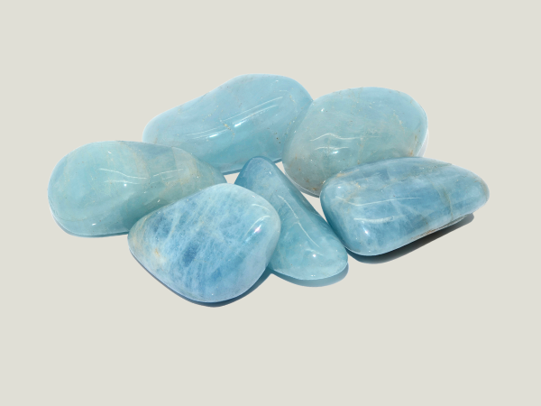 A group of polished blue-green stones on a white surface.