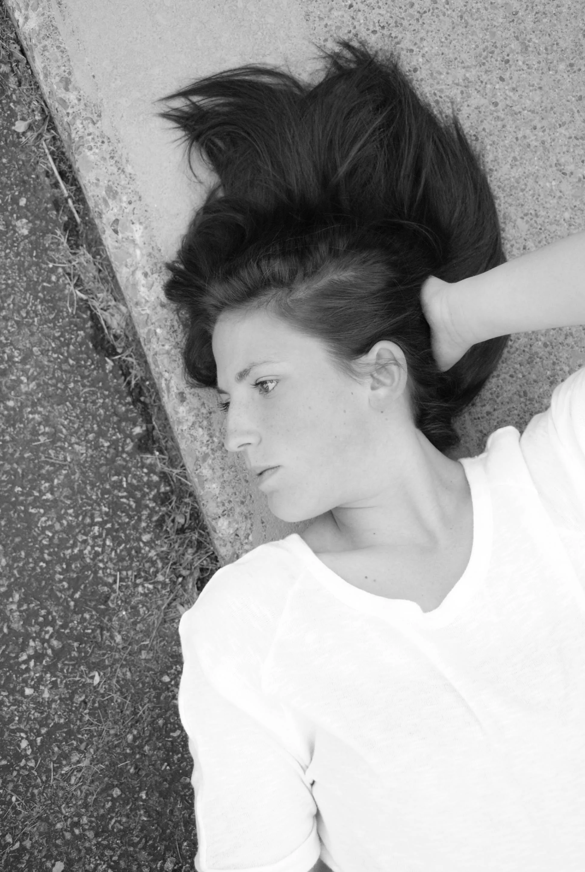 The texture of the pavement and the line of her face…..