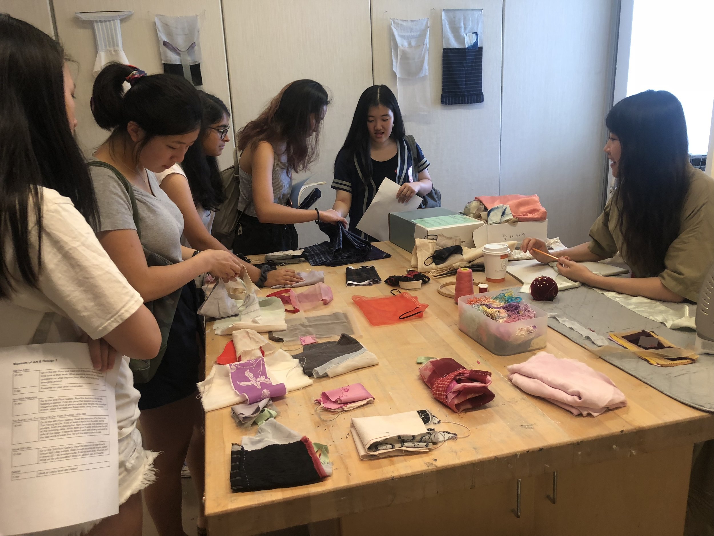 Students examine the textiles Yuchen works with.
