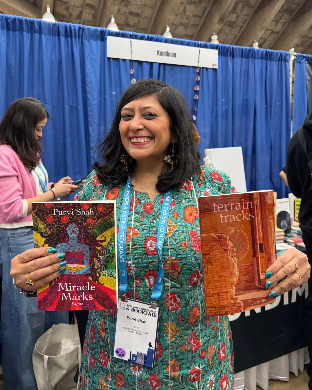 Purvi Shah holding up her books at the Kundiman booth