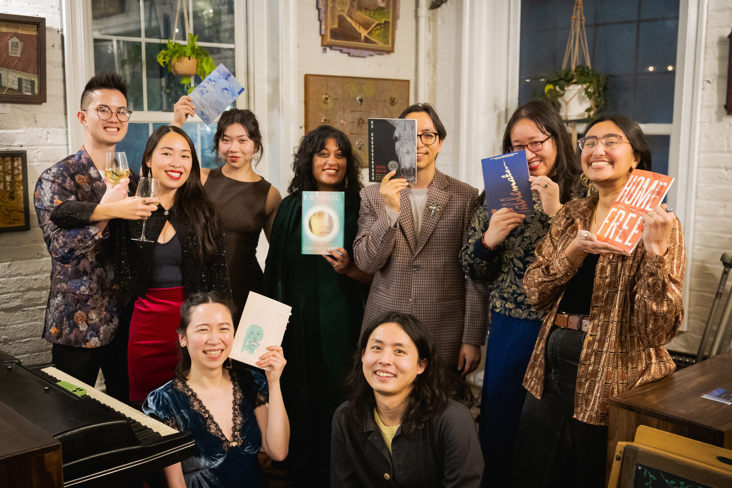 A group shot of the Growing From Our Roots readers holding up their books.