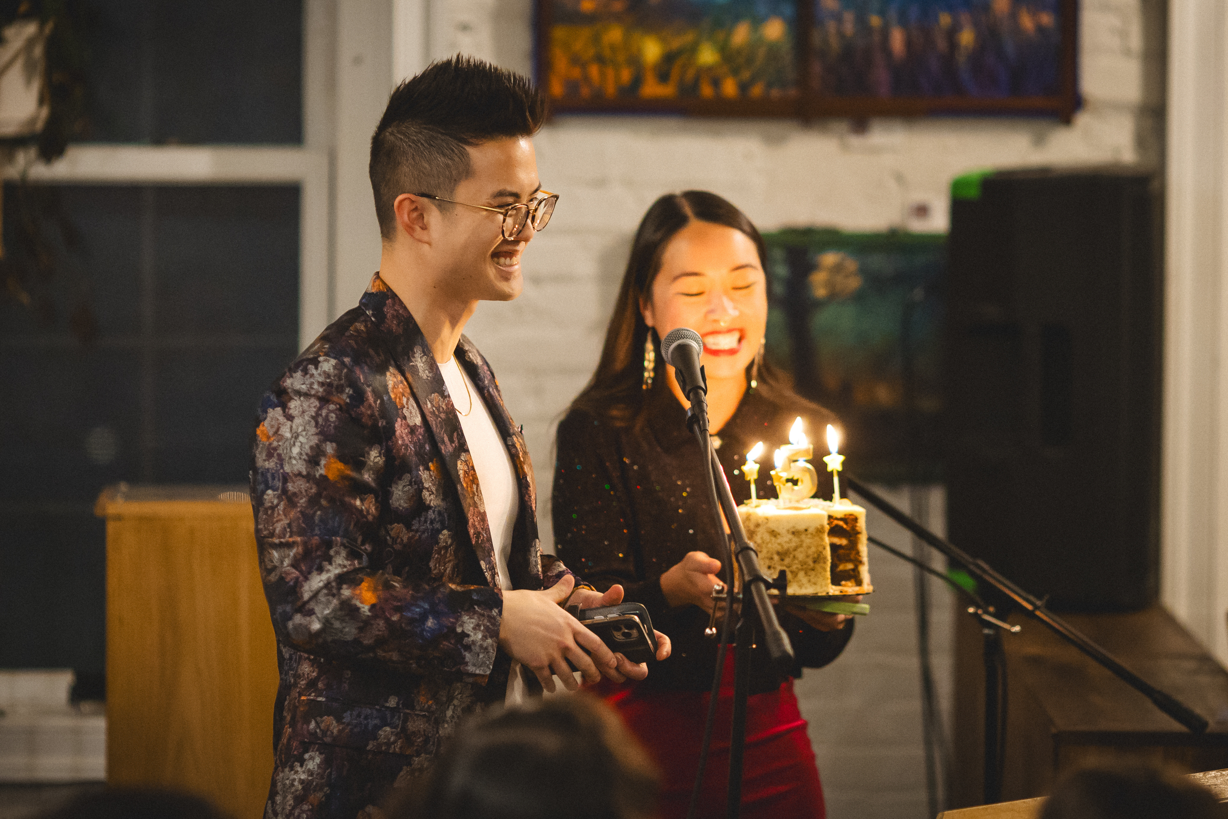 Joshua Nguyen and Susan Nguyen holding up a cake with a number five candle.