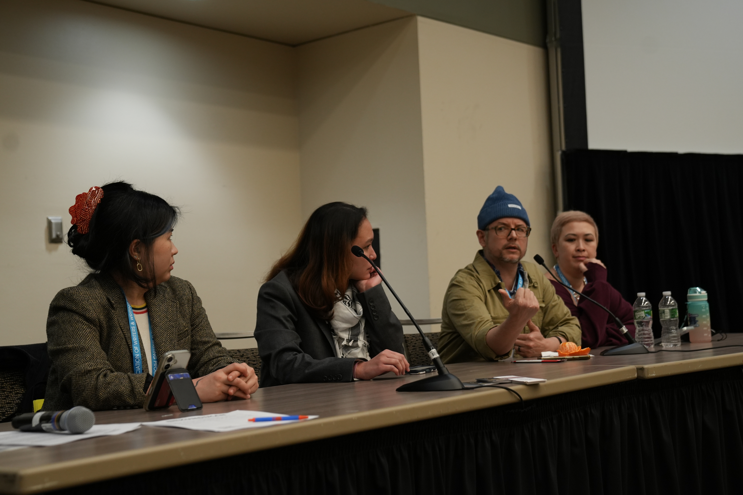 Gina Chung, Soleil David, Lawrence-Minh Bùi Davis, and Mimi Khúc at a desk with microphones during the AAPI Caucus.