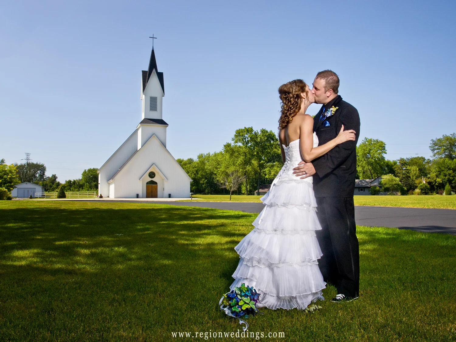 Bride and groom kiss at the entrance to Grace Lutheran Church in Hobart, Indiana.