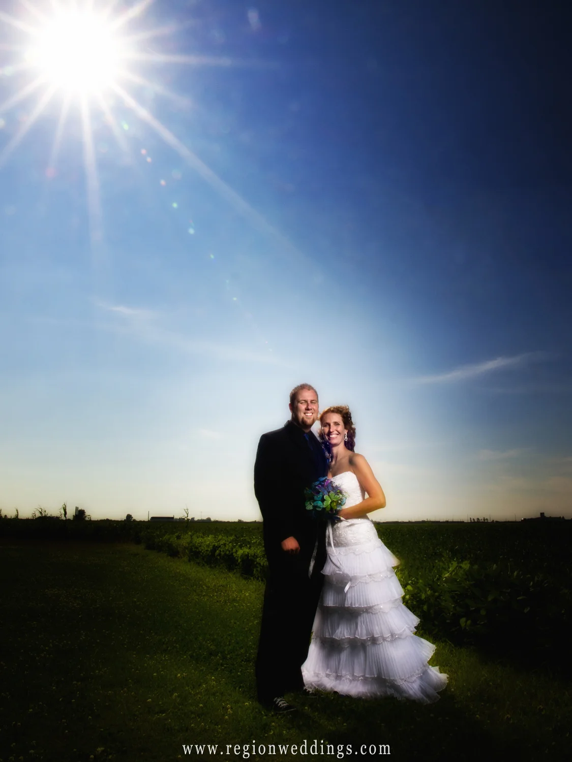 The bride and groom underneath a summer sunburst at an Indiana farm on their wedding day.