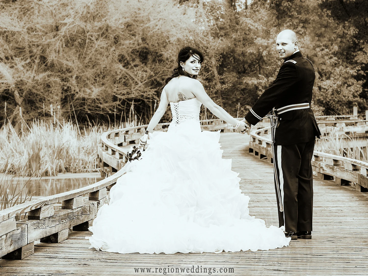The newly married couple takes a stroll across the bridge at White Hawk Country Club in Crown Point.