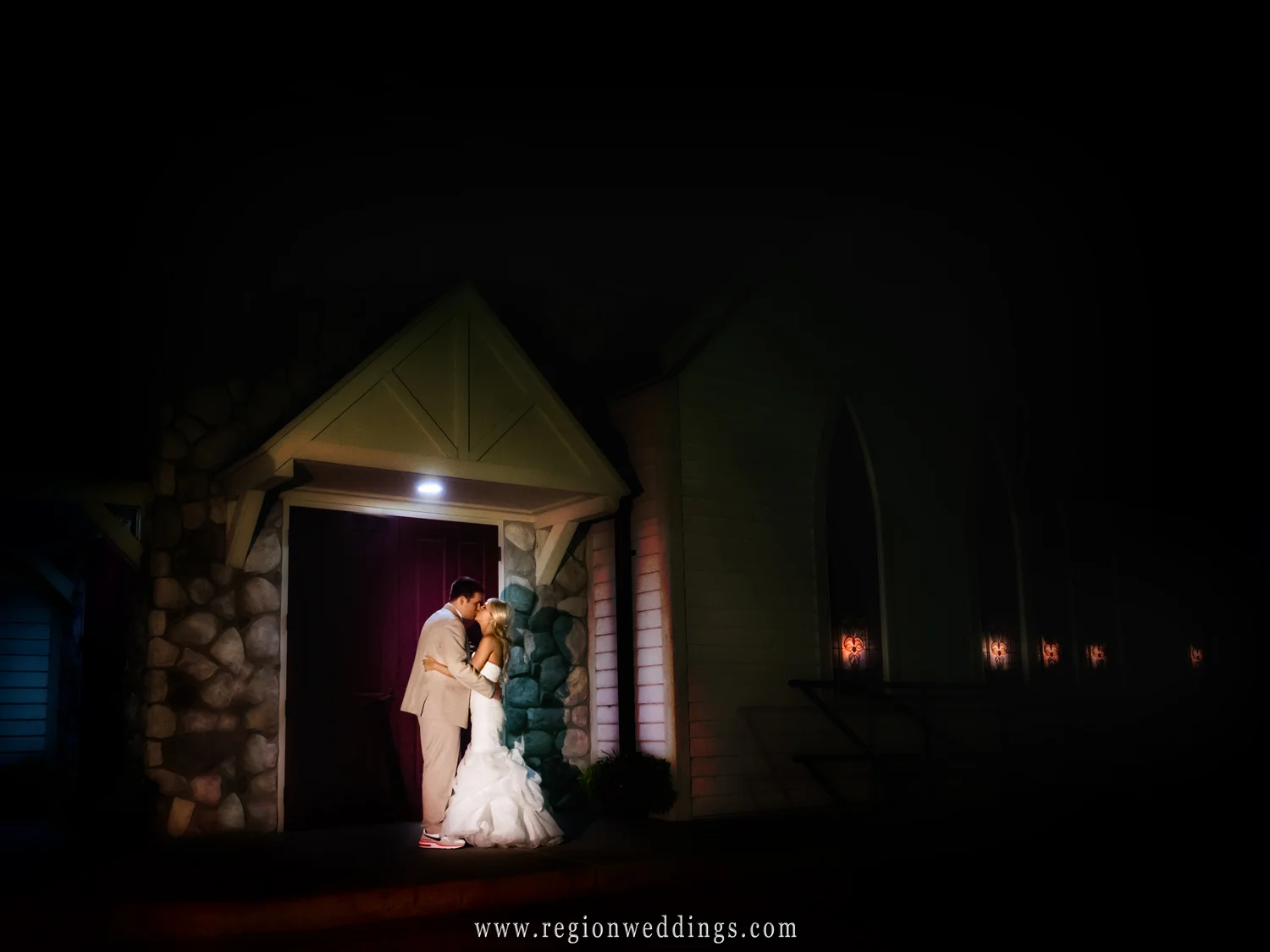 The bride and groom share a kiss underneath the evening stars in front of the Aberdeen chapel in Valparaiso, Indiana.