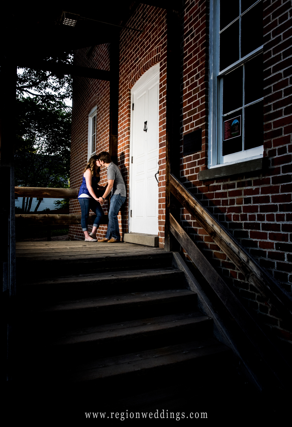 A couple in love kisses at the entrance of the country store at Deep River Park.