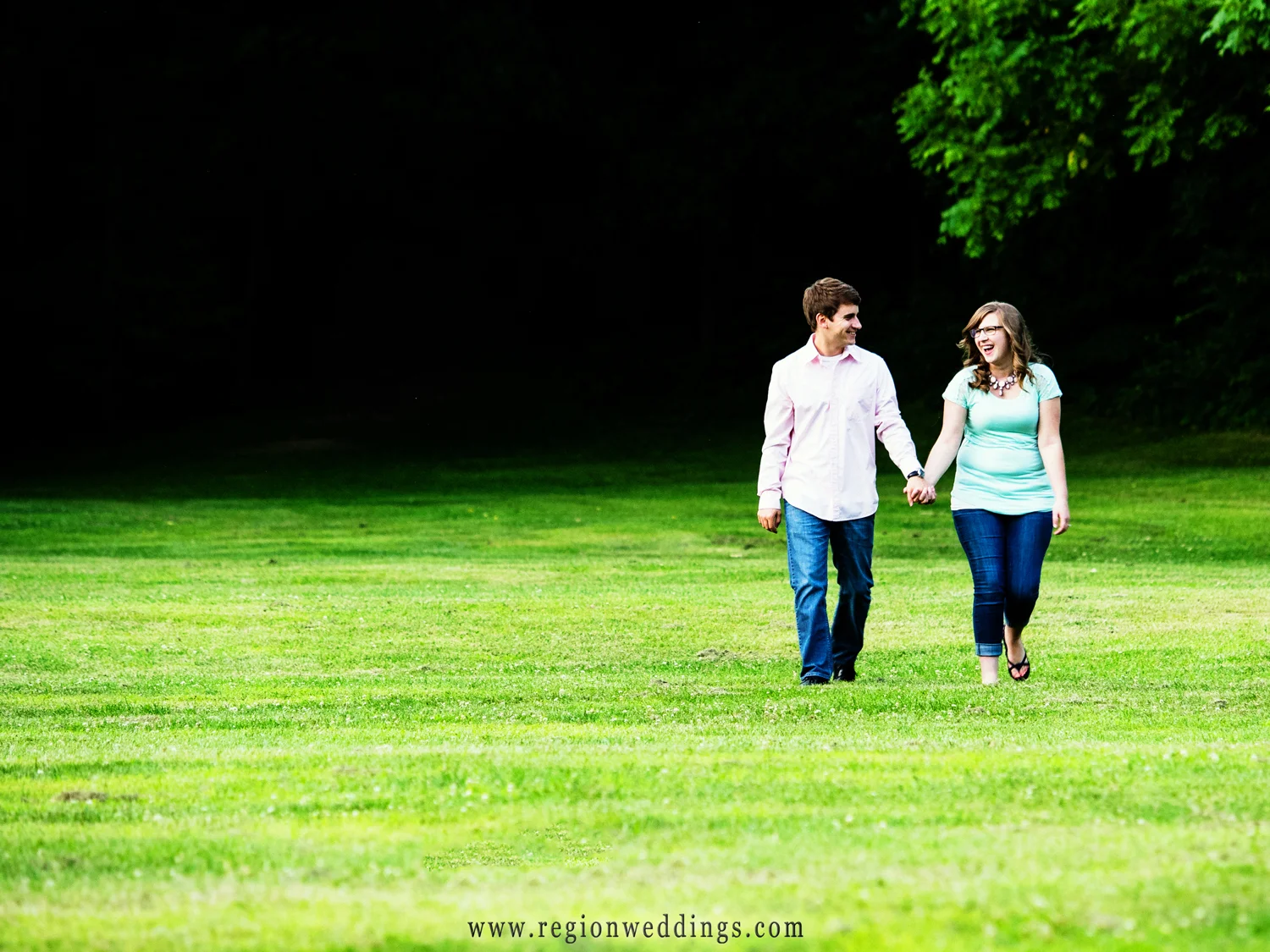 A fun stroll through the grass during an engagement session.