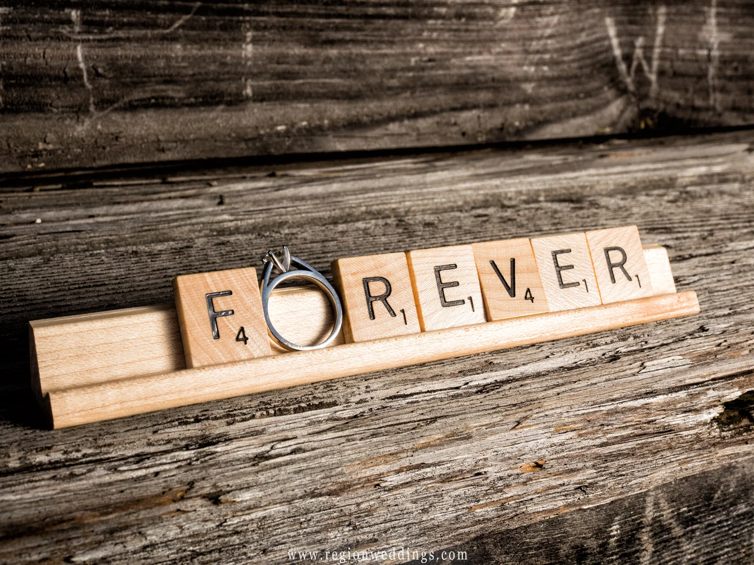 Scrabble letter spell 'forever' with the engagement ring as the letter 'o'.
