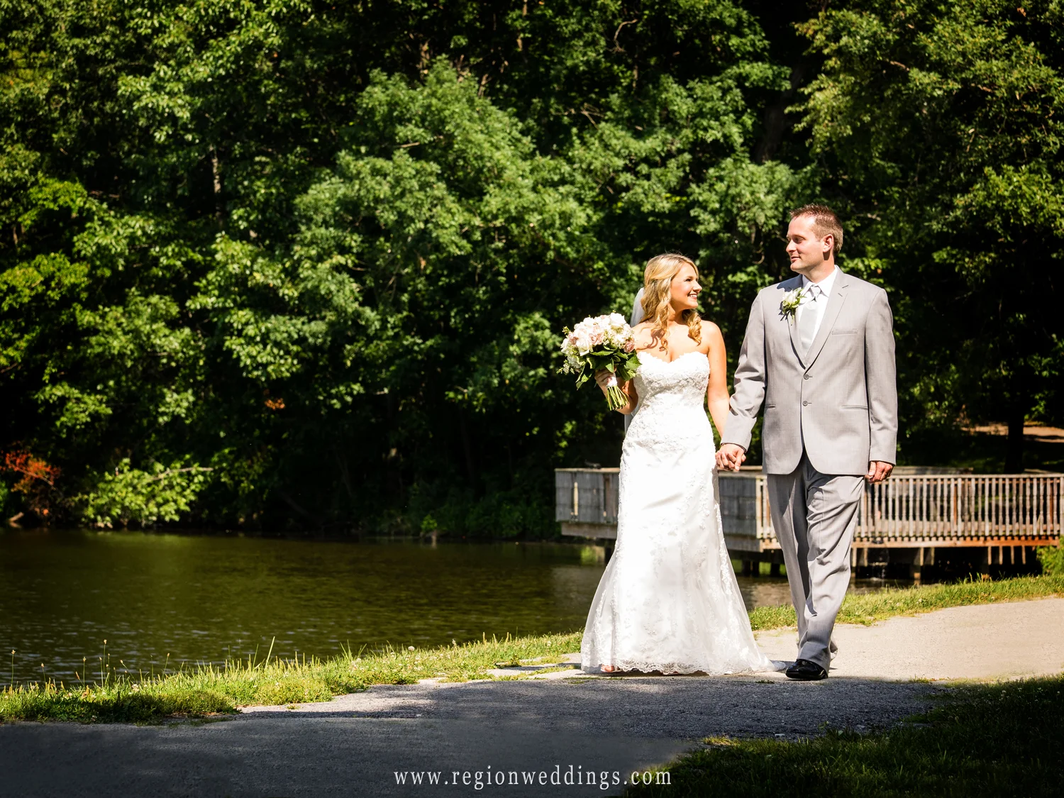 The bride and groom take a romantic stroll along Lemon Lake in Crown Point, Indiana.