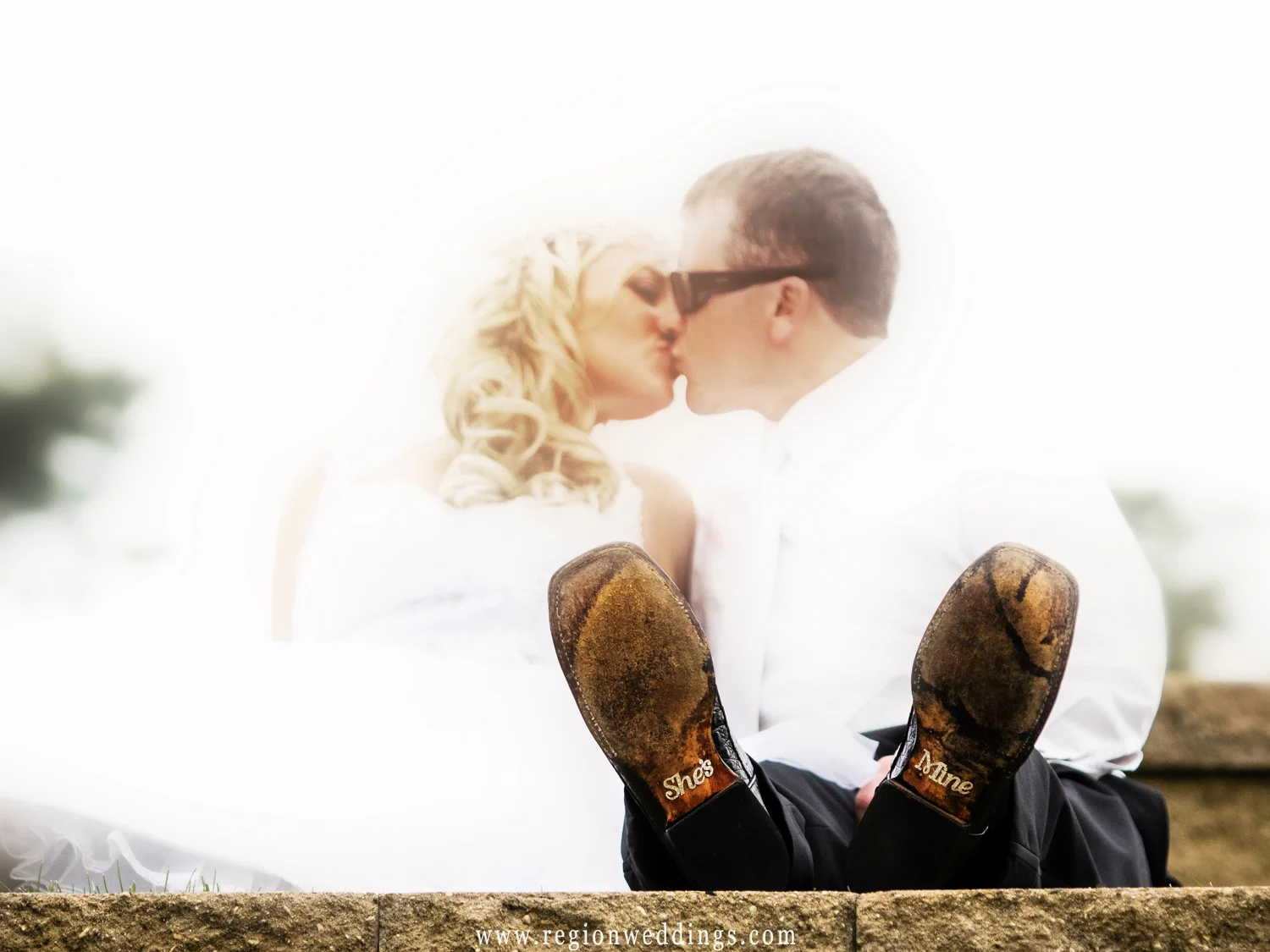 The groom shows off the writing on his wedding shoes.