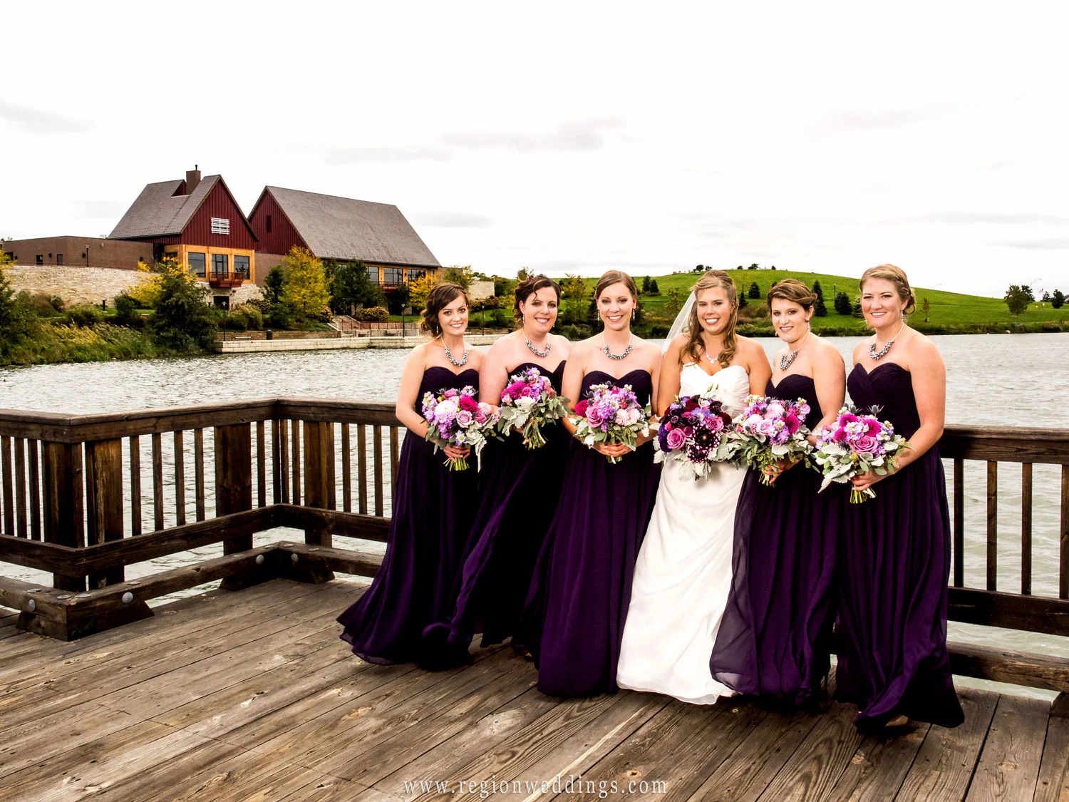 The bridesmaids show off their purple dresses on the bridge that overlooks the Centennial Park clubhouse.
