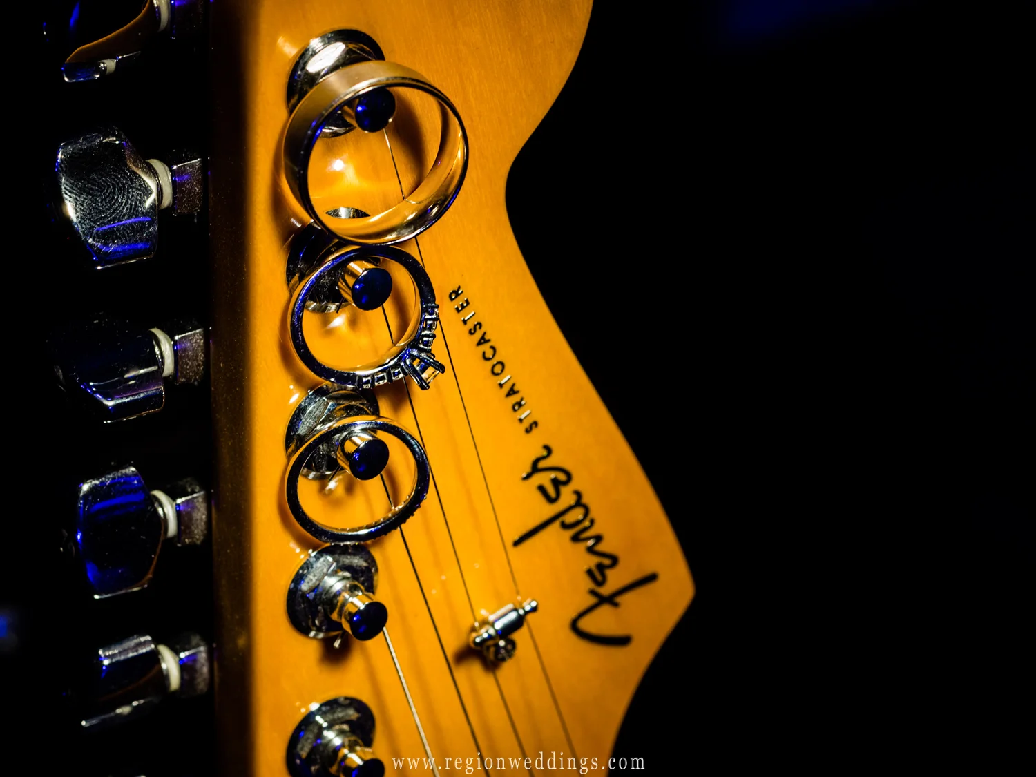 Wedding rings hang from a Fender Stratocaster guitar.