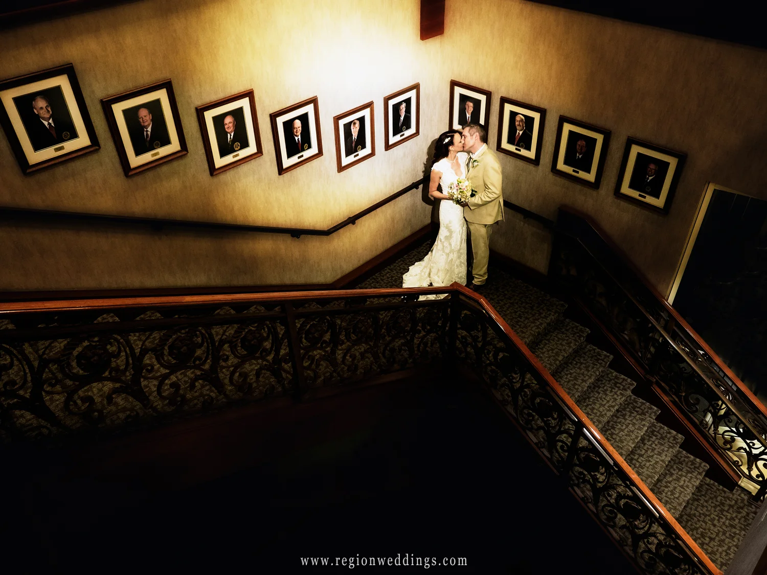 The bride and groom share a romantic kiss on the stairwell at Sand Creek Country Club in Chesterton, Indiana.
