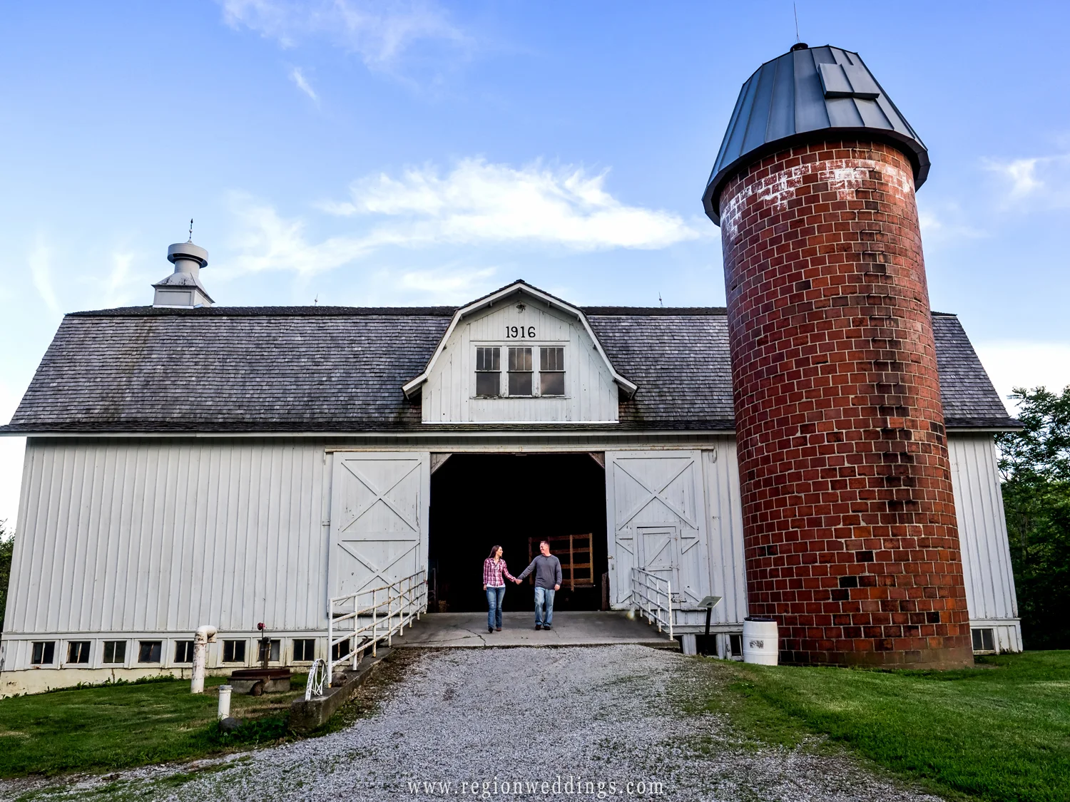 A couple in love walk out of a 1916 era barn at Buckley Homestead.
