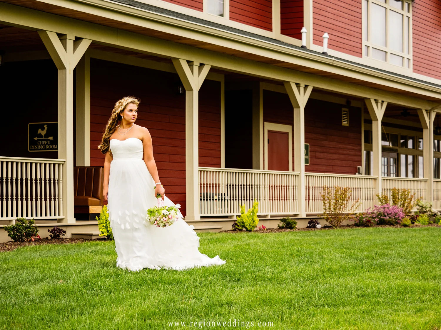 The bride walks alone with her dress trailing behind her.