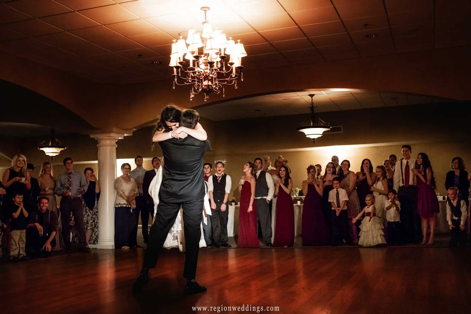The groom lifts the bride into the air at Trinity Hall in Chesterton, Indiana.
