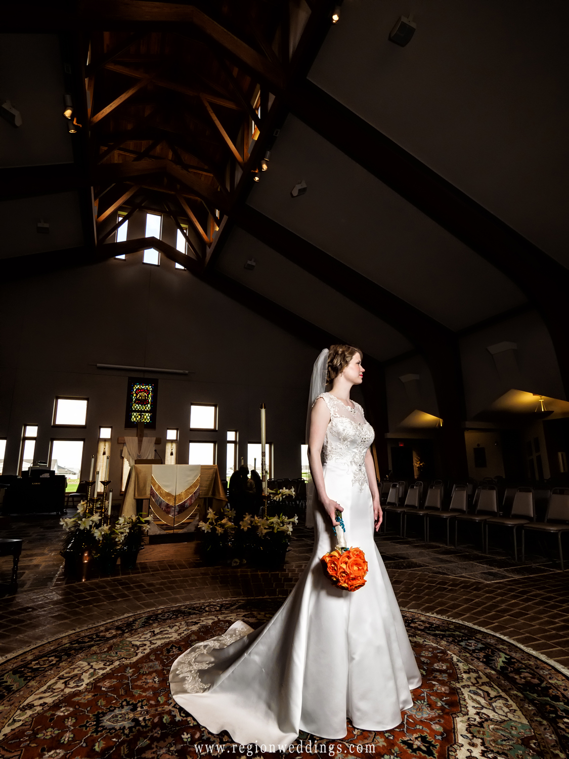 The bride gazes out while holding her bouquet of spring flowers.