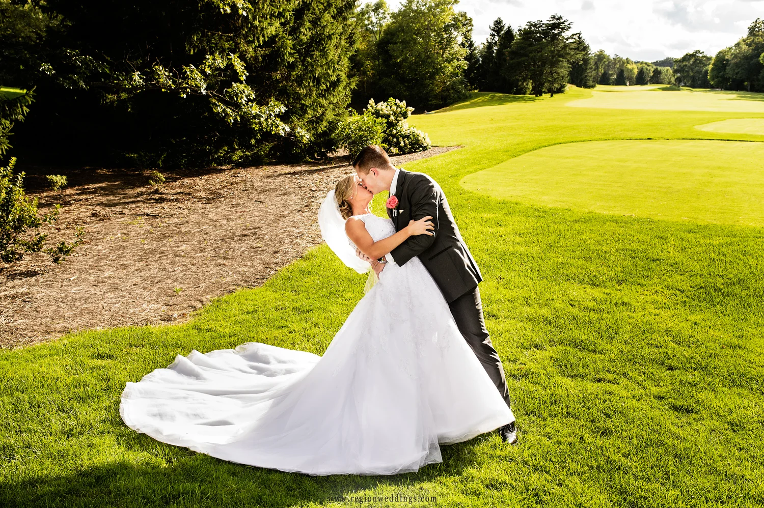 The groom dips his bride on the golf course at Sandy Pines in Demotte, Indiana.