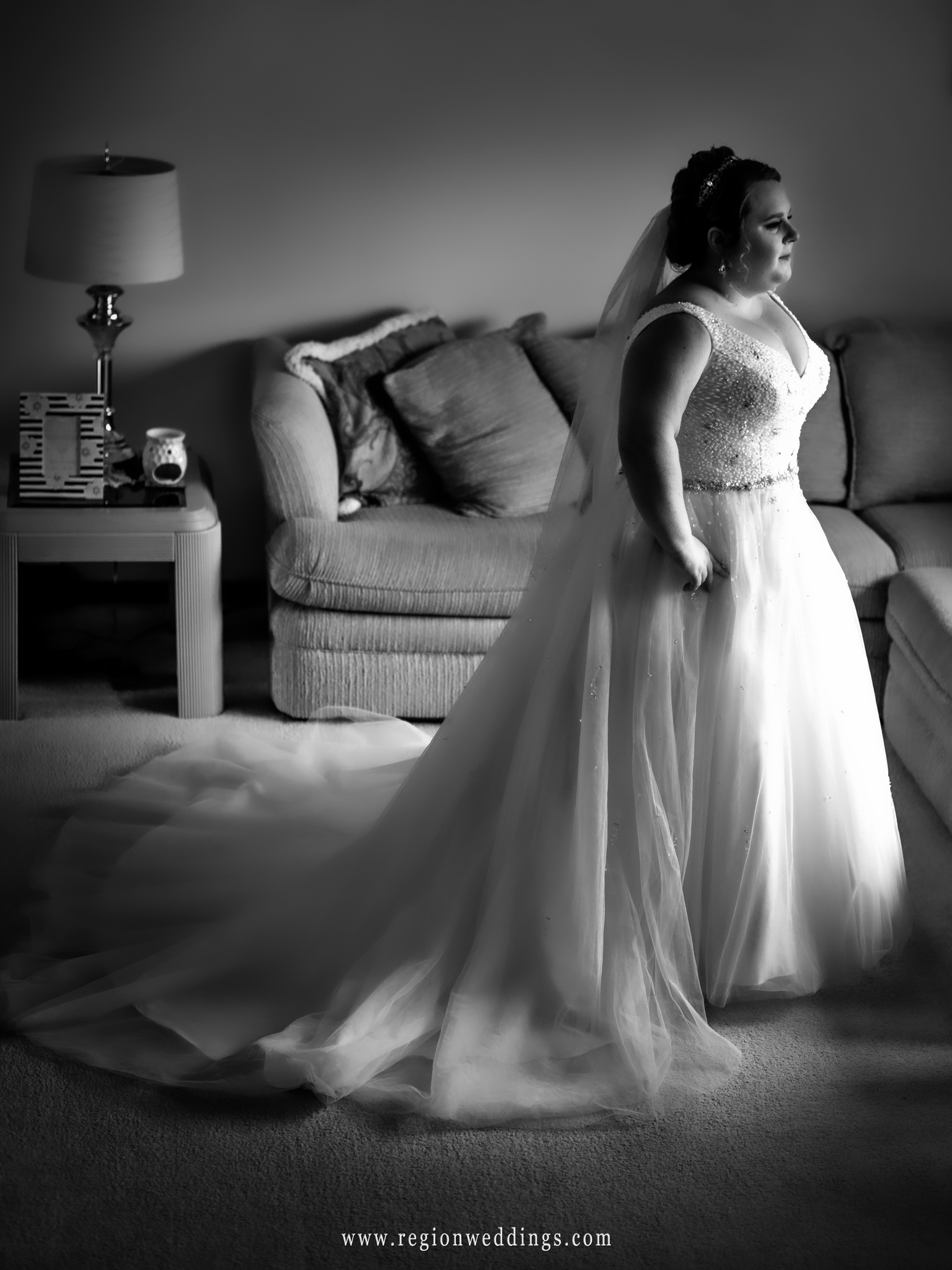 Bride in the window of her parent's home.