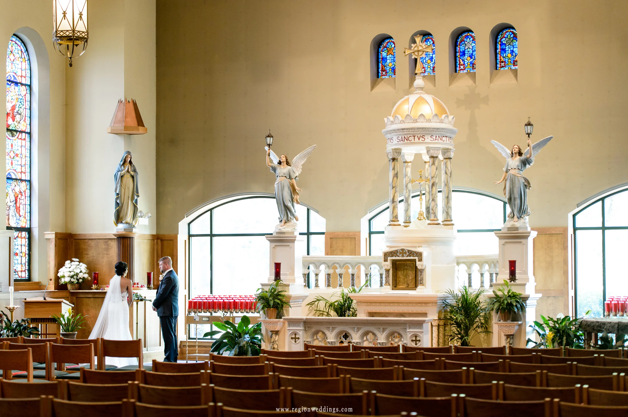 Bride and groom pray to the Virgin Mary in the sanctuary of St. Michael's Parish.