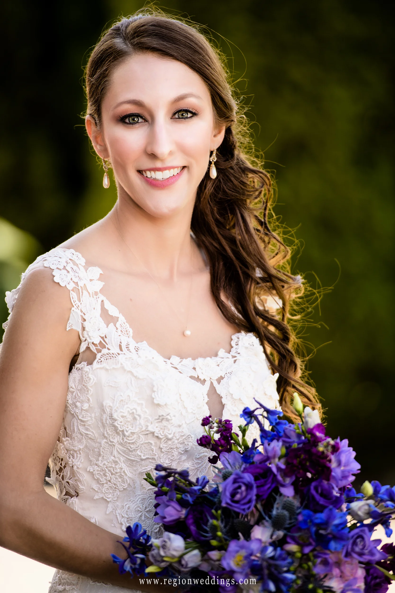 Beautiful bride with a purple and blue bouquet of flowers.