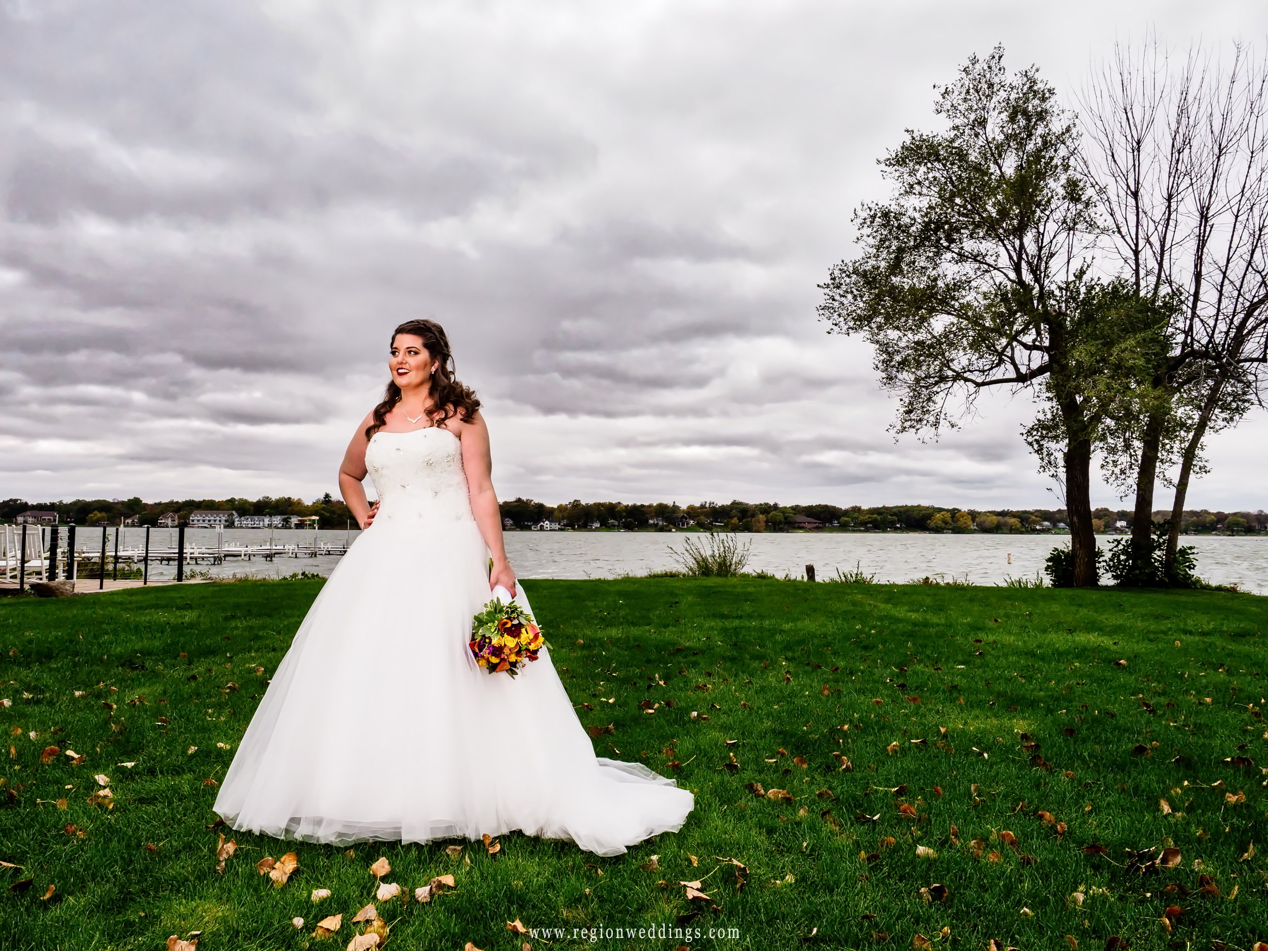The bride lakeside with storm clouds on the horizon.